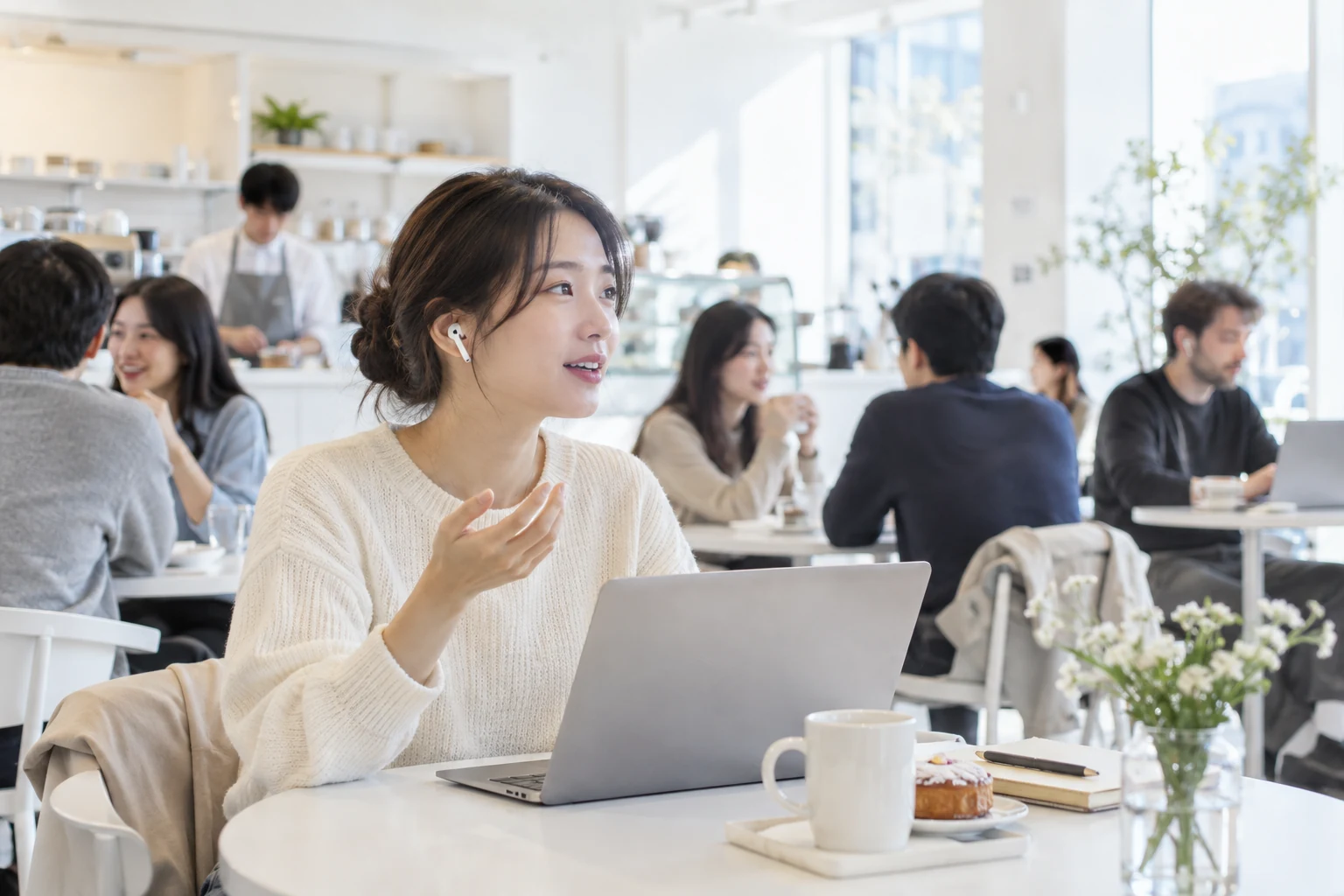 붐비는 카페에서 이어폰으로 음성 에이전트를 사용하는 개발자와 주변 소음이 함께 표현되어 있습니다.